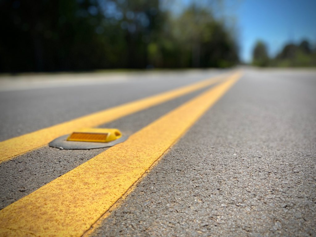 close up of road with yellow center striping