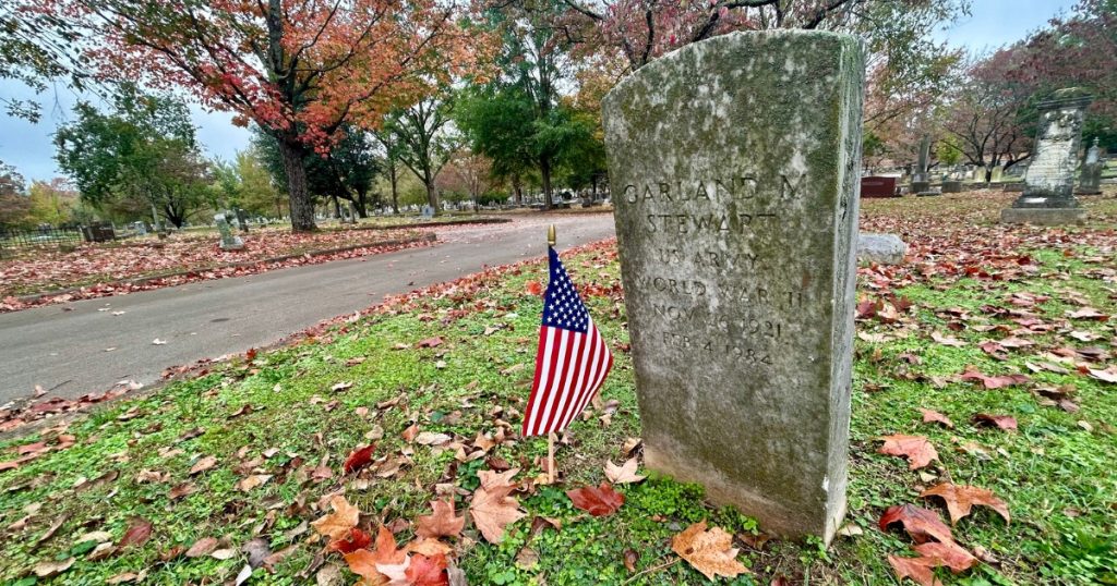 Photo of a headstone at Maple Hill Cemetery for World War II veteran Garland Stewart and an American flag