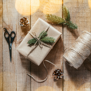 box wrapped in brown paper with roll of twine on right and scissors on left